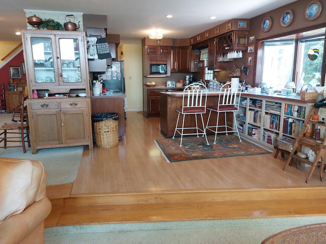 23675 N Shore Dr, Edwardsburg, MI 49112 - kitchen featuring black microwave, light wood finished floors, a kitchen breakfast bar, recessed lighting, and a peninsula