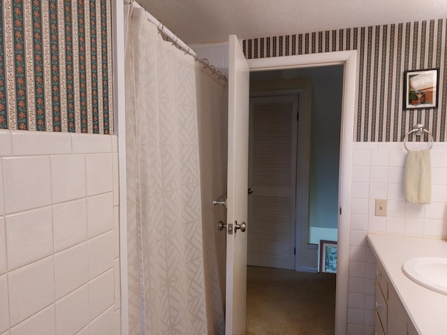 23675 N Shore Dr, Edwardsburg, MI 49112 - full bathroom with tile walls, vanity, wallpapered walls, and a wainscoted wall