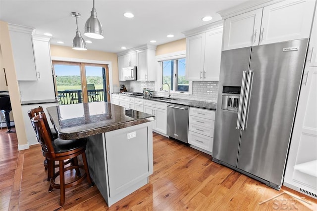 4394 N Francis Shores Ave, Sanford, MI 48657 - kitchen featuring stainless steel appliances, a kitchen island, a kitchen bar, light wood-type flooring, and recessed lighting