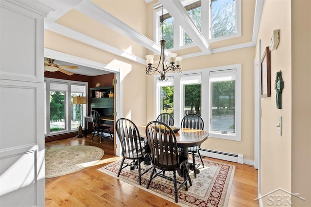 4394 N Francis Shores Ave, Sanford, MI 48657 - dining area with a baseboard heating unit, light wood-style flooring, a chandelier, and ceiling fan