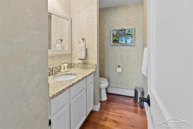 4394 N Francis Shores Ave, Sanford, MI 48657 - bathroom featuring vanity, wood finished floors, and baseboard heating