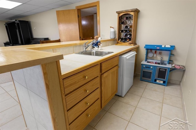 4394 N Francis Shores Ave, Sanford, MI 48657 - kitchen with white dishwasher, light tile patterned floors, tile counters, and a peninsula