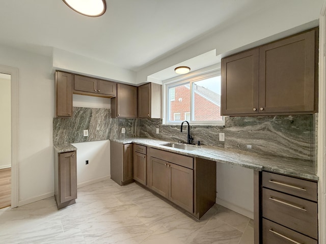 5016 E Outer Dr, Detroit, MI 48234 - kitchen featuring light marble finish floors, backsplash, and light stone counters