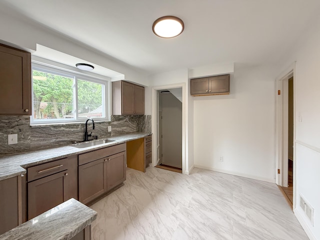 5016 E Outer Dr, Detroit, MI 48234 - kitchen featuring decorative backsplash, light stone countertops, and light marble finish flooring