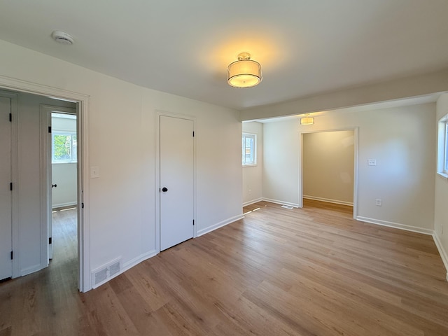5016 E Outer Dr, Detroit, MI 48234 - unfurnished bedroom with multiple windows and light wood-type flooring