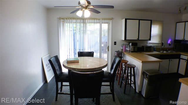 2633 Orchard Ln, Flint, MI 48504 - dining room featuring dark tile patterned flooring, ceiling fan, and plenty of natural light