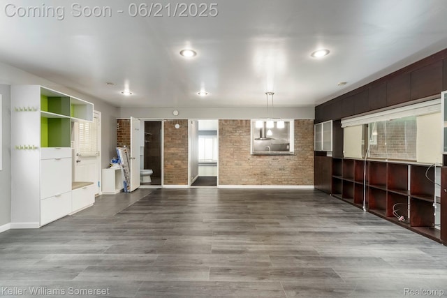 3620 Chester Rd, Royal Oak, MI 48073 - unfurnished living room featuring brick wall, wood finished floors, and recessed lighting