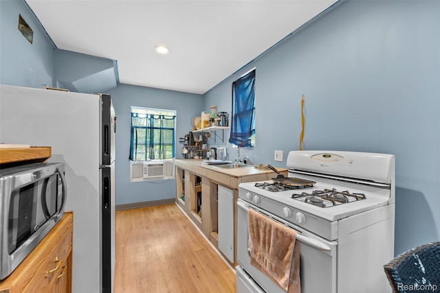 17304 Barlow St, Detroit, MI 48205 - kitchen with white gas range oven, stainless steel microwave, light wood-style flooring, cooling unit, and freestanding refrigerator