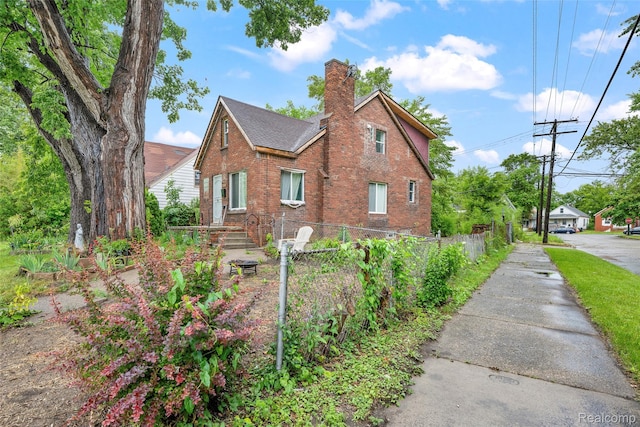 17304 Barlow St, Detroit, MI 48205 - view of property exterior featuring brick siding, a chimney, and roof with shingles