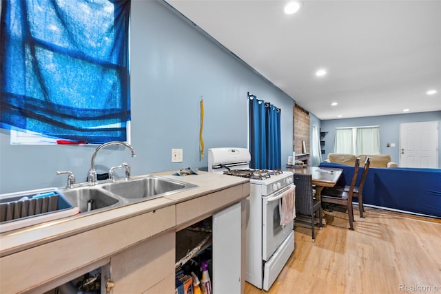 17304 Barlow St, Detroit, MI 48205 - kitchen featuring white range with gas cooktop, light wood-style flooring, recessed lighting, light countertops, and open floor plan