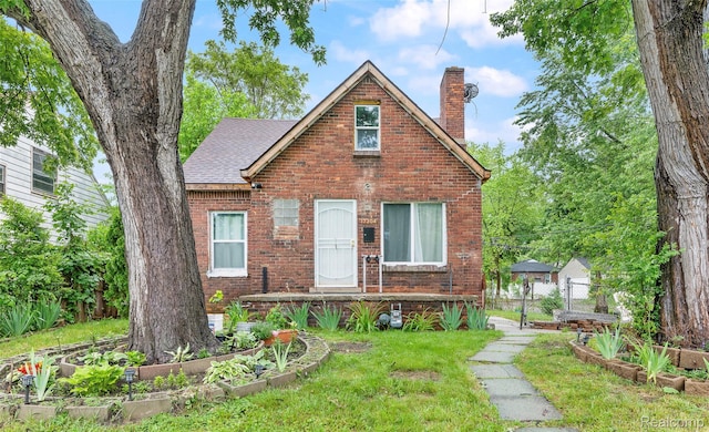 17304 Barlow St, Detroit, MI 48205 - view of front of house with a chimney, brick siding, and roof with shingles