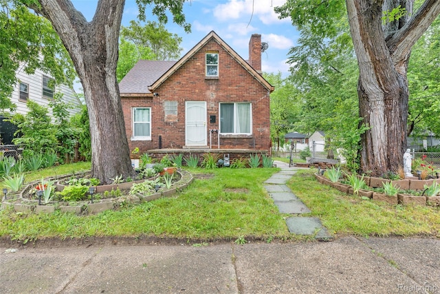 17304 Barlow St, Detroit, MI 48205 - view of front facade with a vegetable garden, a chimney, and brick siding