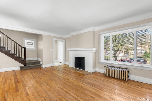 3225 Leslie St, Detroit, MI 48238 - unfurnished living room with radiator, light wood finished floors, crown molding, stairway, and a fireplace