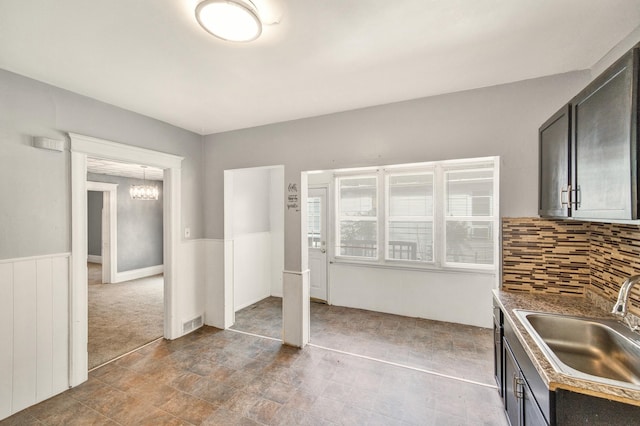 269 Euclid St, Mount Clemens, MI 48043 - kitchen with backsplash, stone finish floors, dark cabinets, and a chandelier