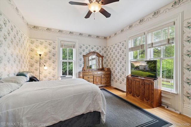 6501 River Rd, Flushing, MI 48433 - bedroom featuring wood finished floors, wallpapered walls, and a ceiling fan