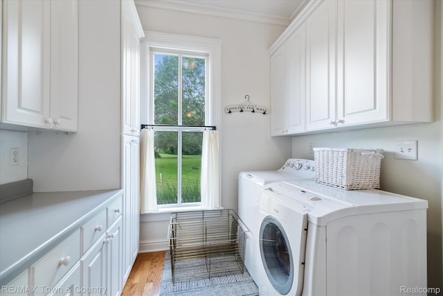 6501 River Rd, Flushing, MI 48433 - laundry area with cabinet space, washing machine and clothes dryer, light wood-style floors, and ornamental molding
