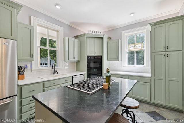 6501 River Rd, Flushing, MI 48433 - kitchen with green cabinetry, appliances with stainless steel finishes, a breakfast bar area, backsplash, and crown molding