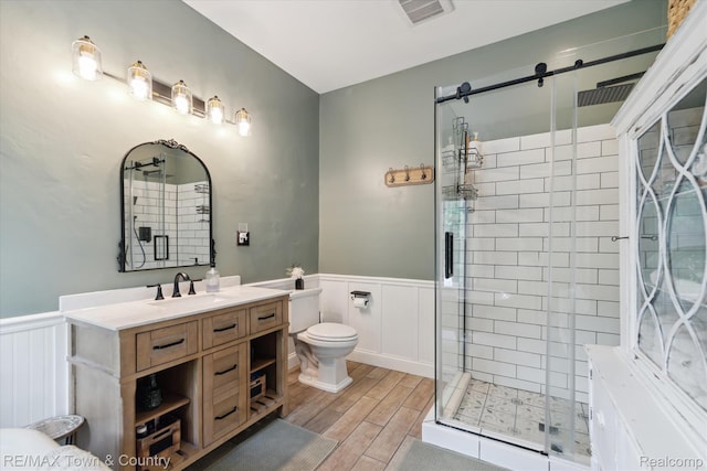 6501 River Rd, Flushing, MI 48433 - full bathroom with a wainscoted wall, a stall shower, a decorative wall, vanity, and wood finished floors