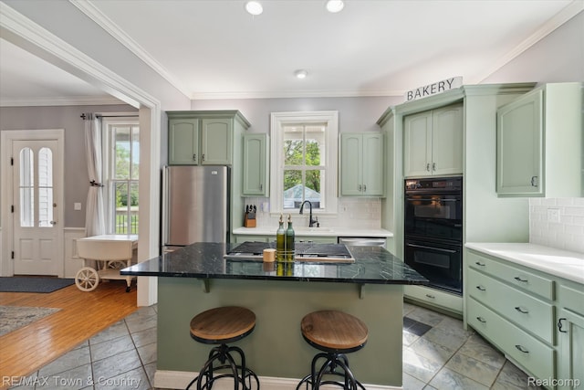 6501 River Rd, Flushing, MI 48433 - kitchen with green cabinets, stainless steel appliances, a breakfast bar area, healthy amount of natural light, and recessed lighting
