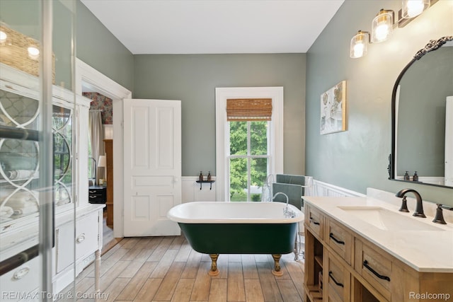 6501 River Rd, Flushing, MI 48433 - bathroom with vanity, a soaking tub, wood finished floors, and a wainscoted wall