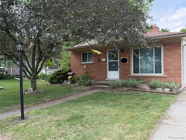 400 W Hudson Ave, Madison Heights, MI 48071 - view of front of property with brick siding, a front lawn, and a chimney