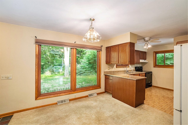 15770 157th Ave, Big Rapids, MI 49307 - kitchen featuring black electric range oven, freestanding refrigerator, a peninsula, a chandelier, and brown cabinetry
