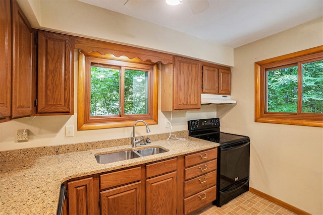 15770 157th Ave, Big Rapids, MI 49307 - kitchen with black / electric stove, under cabinet range hood, healthy amount of natural light, and brown cabinetry