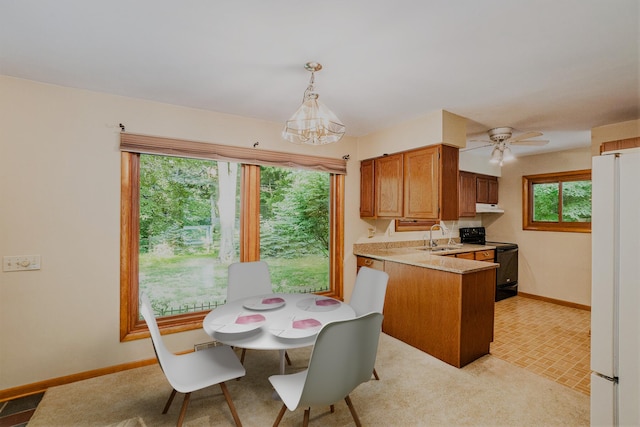 15770 157th Ave, Big Rapids, MI 49307 - kitchen with black / electric stove, freestanding refrigerator, light countertops, a peninsula, and decorative light fixtures