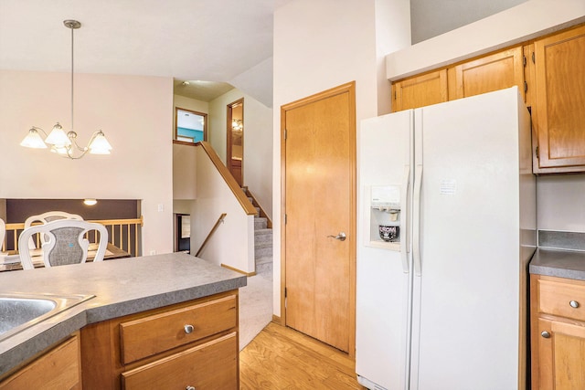 5767 E Grove Dr SE, Kentwood, MI 49512 - kitchen with white refrigerator with ice dispenser, light wood finished floors, a chandelier, and pendant lighting