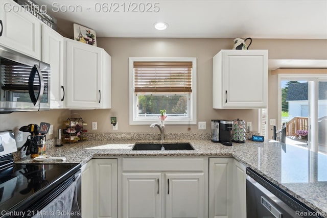 9145 Woodridge Dr, Davison, MI 48423 - kitchen featuring stainless steel appliances, white cabinets, recessed lighting, and light stone counters