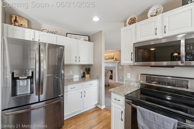 9145 Woodridge Dr, Davison, MI 48423 - kitchen with stainless steel appliances, light wood-type flooring, white cabinetry, and recessed lighting