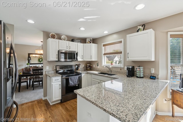 9145 Woodridge Dr, Davison, MI 48423 - kitchen featuring stainless steel appliances, a peninsula, light wood-style floors, white cabinetry, and recessed lighting