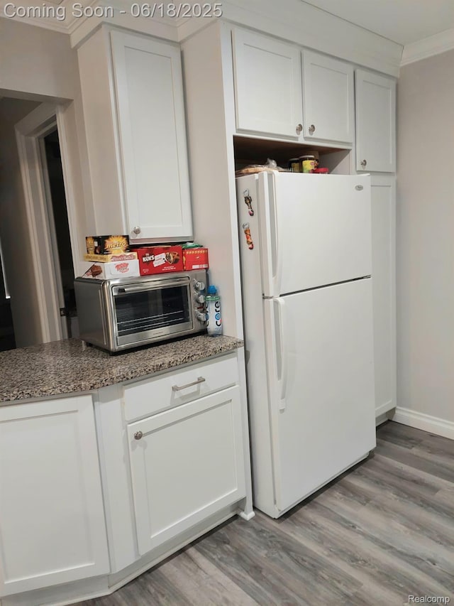 679 Judith St, Westland, MI 48186 - kitchen with freestanding refrigerator, ornamental molding, light wood-style flooring, and light stone countertops
