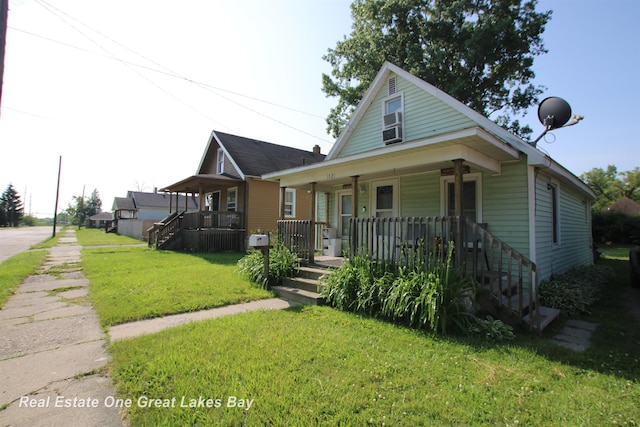 1521 Stanley St, Saginaw, MI 48602 - view of front of property with covered porch, a front lawn, and stairway