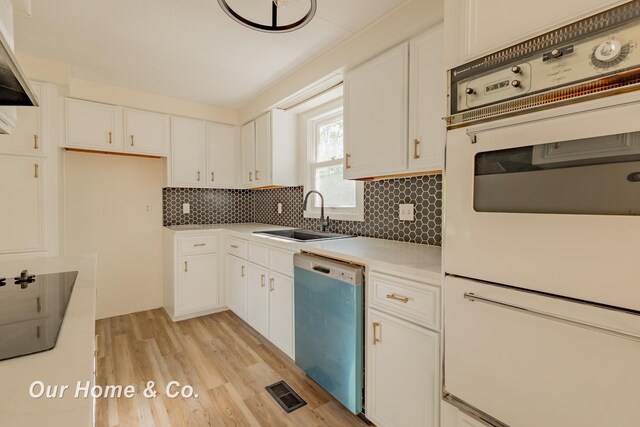838 S Grey Rd, Midland, MI 48640 - kitchen with dishwashing machine, white double oven, backsplash, light wood finished floors, and white cabinets