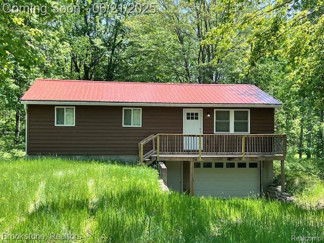 5776 Northover Cir, Elmira, MI 49730 - view of front of property featuring a metal roof, a forest view, and a wooden deck