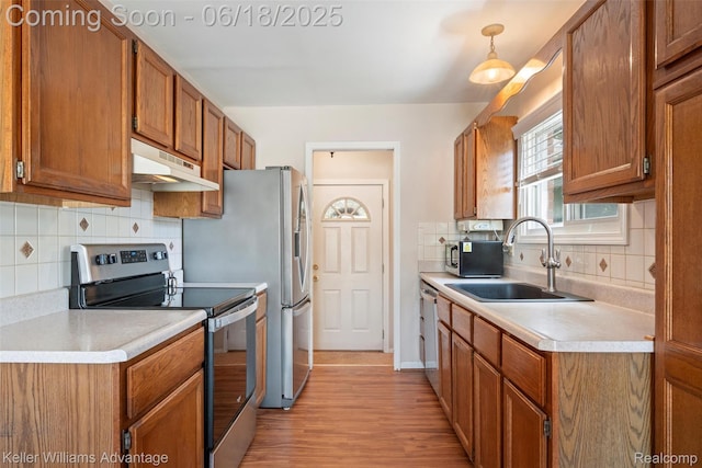 37862 Parkhurst St, Livonia, MI 48154 - kitchen with electric stove, under cabinet range hood, brown cabinetry, backsplash, and light countertops