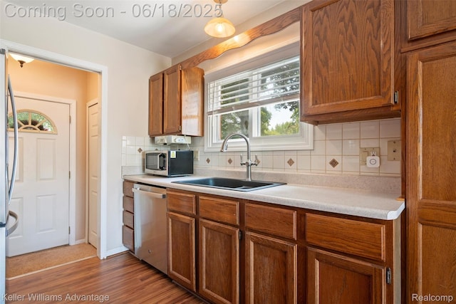 37862 Parkhurst St, Livonia, MI 48154 - kitchen featuring stainless steel appliances, light countertops, decorative backsplash, and brown cabinets