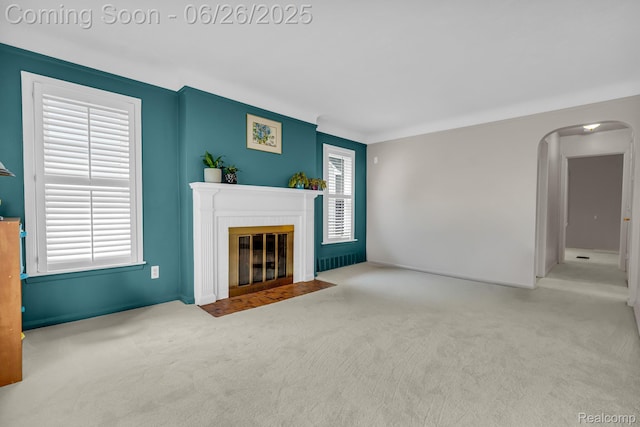 2734 Vassar St, Dearborn, MI 48124 - unfurnished living room with arched walkways, a fireplace with flush hearth, and carpet