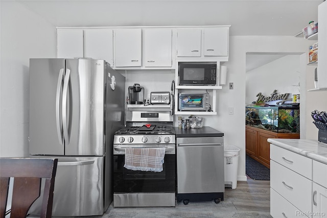 11228 Hudson Ave, Warren, MI 48089 - kitchen with stainless steel appliances, light wood-type flooring, white cabinetry, and light countertops