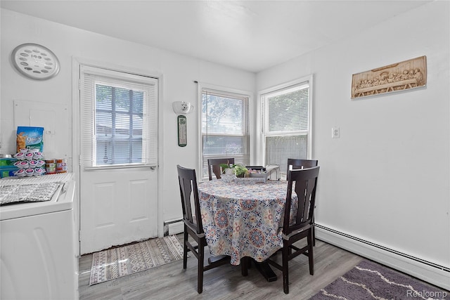 11228 Hudson Ave, Warren, MI 48089 - dining room featuring baseboard heating, washer / clothes dryer, healthy amount of natural light, and light wood-style flooring