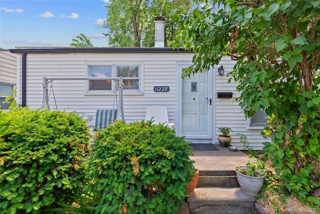 11228 Hudson Ave, Warren, MI 48089 - doorway to property featuring a chimney