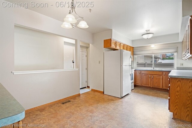 14000 Ellen Dr, Livonia, MI 48154 - kitchen featuring white appliances, brown cabinetry, a chandelier, and decorative light fixtures