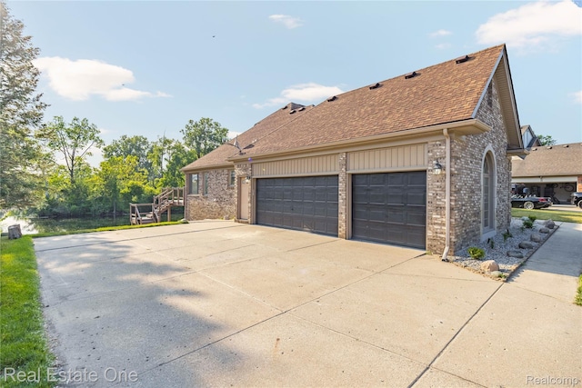 52615 Seven Oaks Dr, Shelby Twp, MI 48316 - view of side of property featuring brick siding, driveway, a shingled roof, and a garage