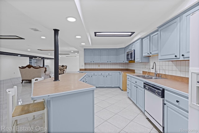52615 Seven Oaks Dr, Shelby Twp, MI 48316 - kitchen featuring dishwasher, stainless steel microwave, light tile patterned floors, backsplash, and recessed lighting