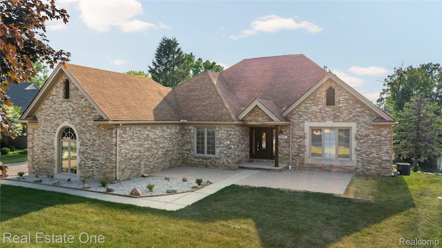 52615 Seven Oaks Dr, Shelby Twp, MI 48316 - view of front facade featuring a front lawn, a patio area, brick siding, and a shingled roof