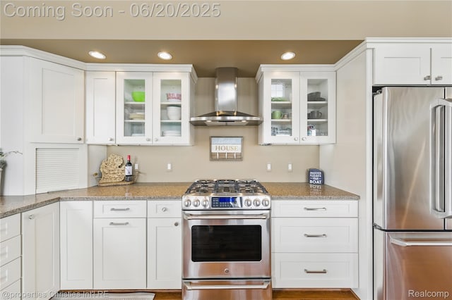 11693 Kenton Dr, Whitmore Lake, MI 48189 - kitchen with appliances with stainless steel finishes, wall chimney exhaust hood, white cabinetry, and recessed lighting