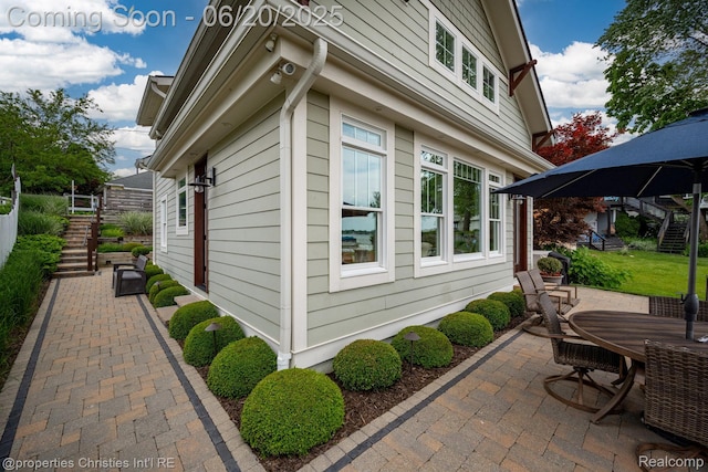 11693 Kenton Dr, Whitmore Lake, MI 48189 - view of home's exterior featuring stairway, a patio area, and outdoor dining space