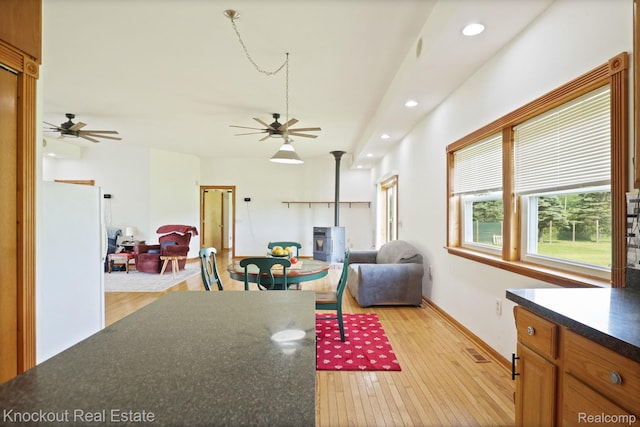 5490 Rupprecht Rd, Vassar, MI 48768 - living room featuring ceiling fan, recessed lighting, a wood stove, and light wood finished floors