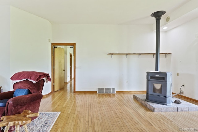 5490 Rupprecht Rd, Vassar, MI 48768 - living area with a wood stove, heating unit, and hardwood / wood-style flooring